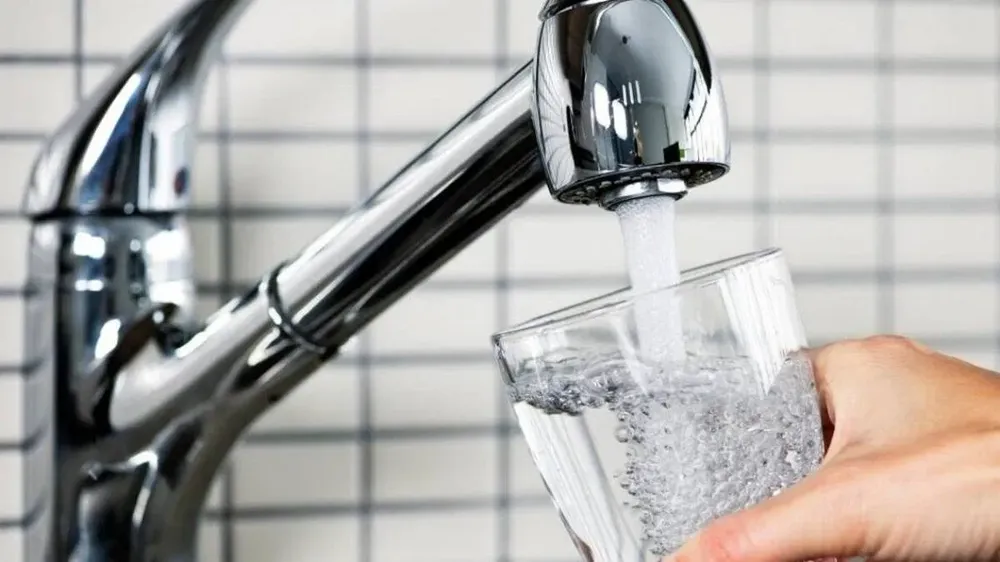 A glass filling from a kitchen tap